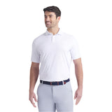 Man wearing a white polo shirt and light gray pants on a white background