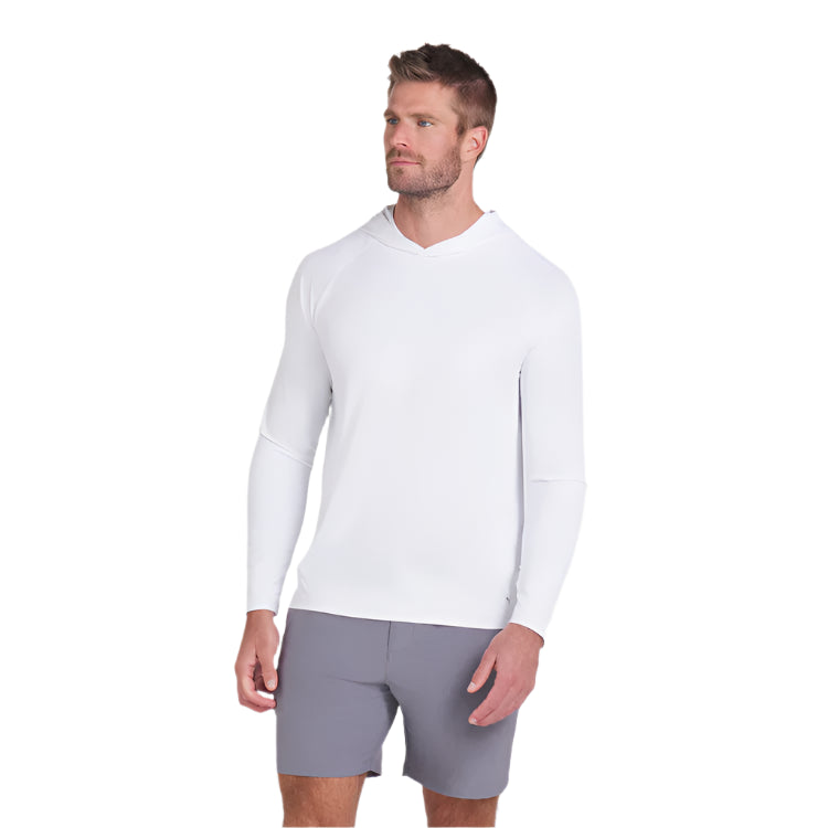 Man wearing a white long-sleeve shirt and gray shorts on a light gray background